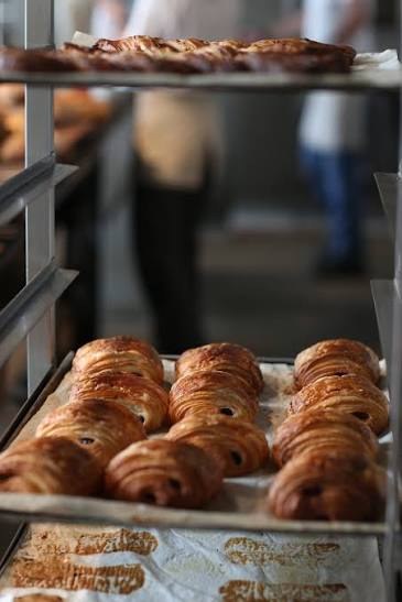 Een bakplaat met chocoladebroodjes op een rek in de bakkerij